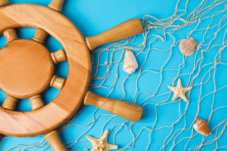 Helm, net and sea shells on color background