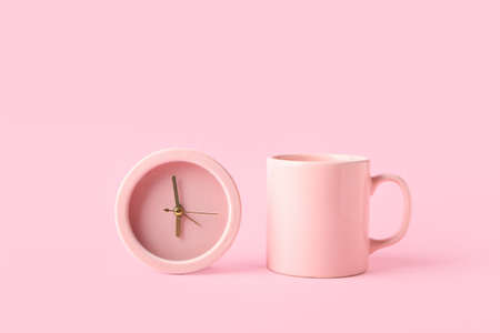 Alarm clock and cup on color backgroundの写真素材