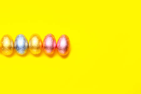 Sweet chocolate eggs on color background