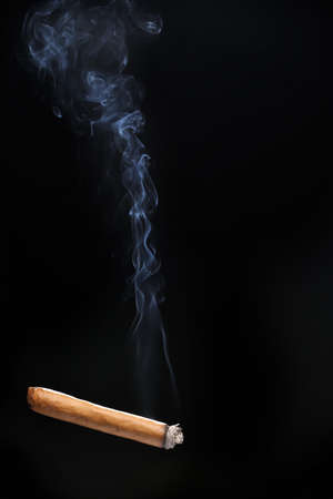 Cigarette with smoke on dark background