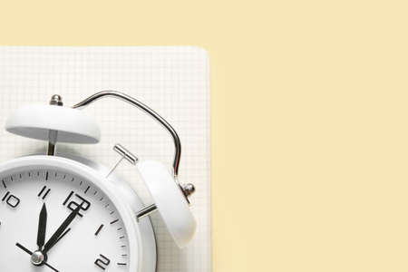 Alarm clock and notebook on color background, closeupの写真素材