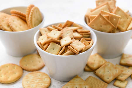 Bowls of crackers on light backgroundの写真素材