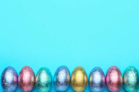 Sweet chocolate eggs on color background