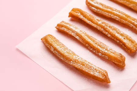 Parchment with tasty churros on color background, closeupの写真素材