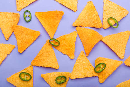 Tasty nachos with chili pepper on color backgroundの写真素材