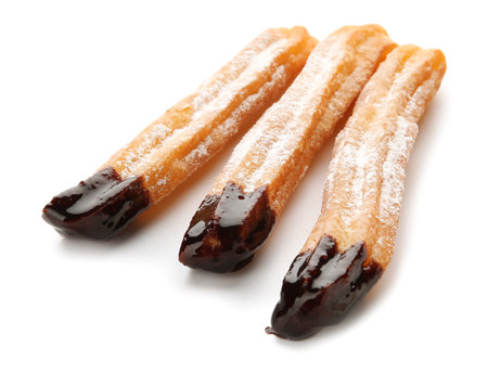 Tasty churros dipped in chocolate on white backgroundの写真素材