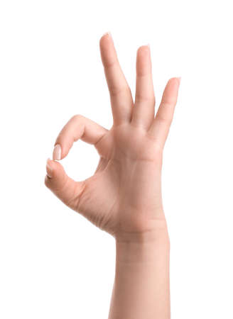 Female hand showing OK gesture on white backgroundの写真素材