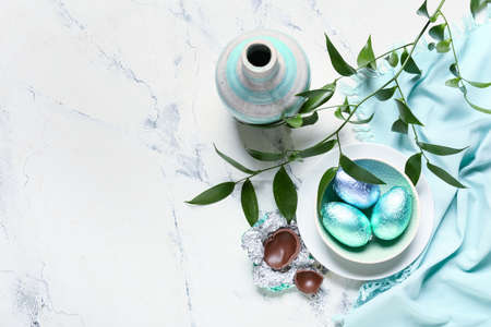 Beautiful composition with chocolate Easter eggs on light background