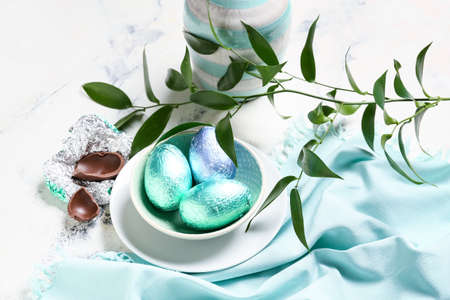 Beautiful composition with chocolate Easter eggs on light background