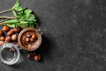 Jar with tasty chocolate paste and hazelnuts on dark backgroundの写真素材