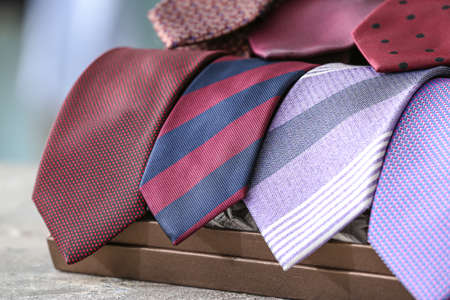 Box with many stylish neckties on table, closeupの写真素材