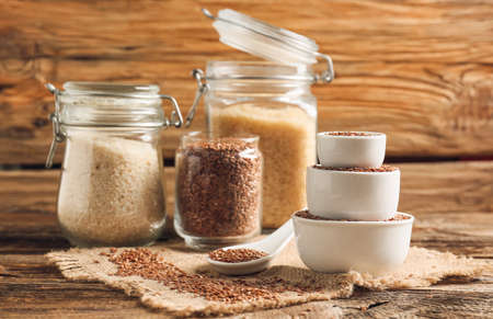 Composition with bowls and jars of flax seeds on wooden backgroundの写真素材