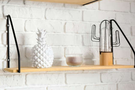 Modern shelf with decor hanging on brick wallの写真素材