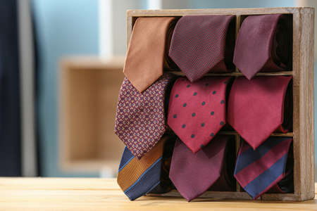 Box with stylish neckties on tableの写真素材