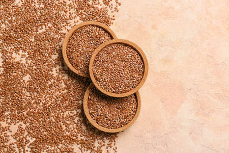 Bowls with flax seeds on color backgroundの写真素材
