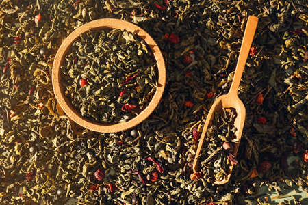 Scoop and bowl on dry green tea leaves