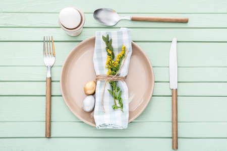 Beautiful table setting for Easter celebration on color wooden backgroundの写真素材