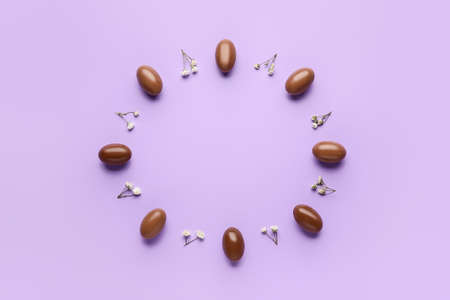 Composition with chocolate Easter eggs on color background