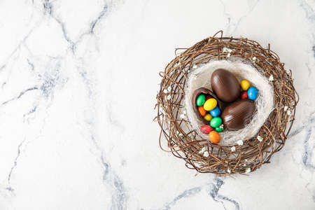 Nest with chocolate Easter eggs on light backgroundの写真素材