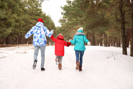 Happy family walking in park on winter dayの写真素材