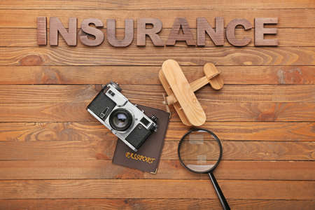 Composition with word INSURANCE and photo camera on wooden backgroundの写真素材