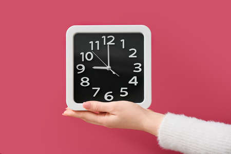 Female hand with stylish clock on color background, closeup