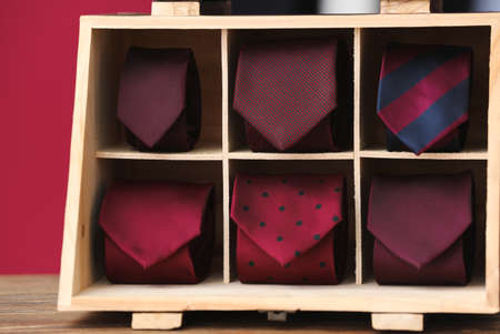 Wooden box with stylish neckties on tableの写真素材
