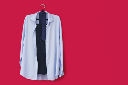 Stylish male clothes hanging on color wallの写真素材