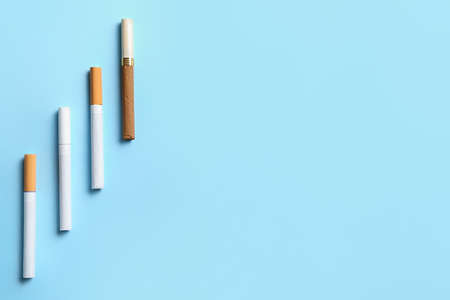Different cigarettes on color background