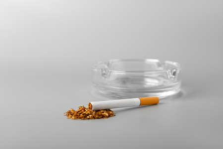 Ash tray with cigarette on light backgroundの写真素材