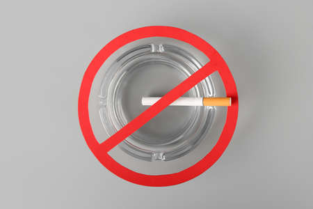 STOP sign with ash tray and cigarette on light backgroundの写真素材