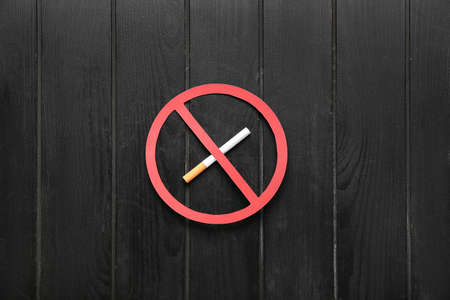STOP sign with cigarette on dark wooden backgroundの写真素材