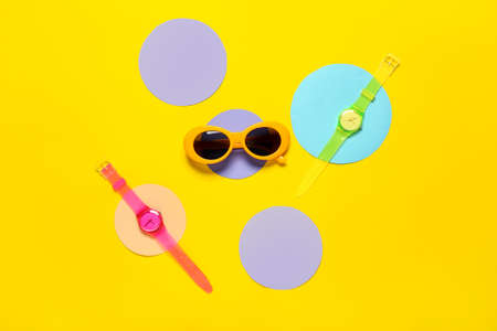 Composition with stylish sunglasses and wrist watch on color backgroundの写真素材