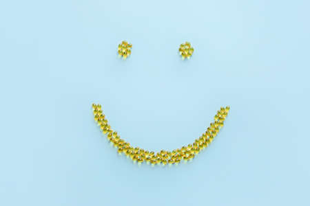 Smile made of vitamin A pills on color backgroundの写真素材