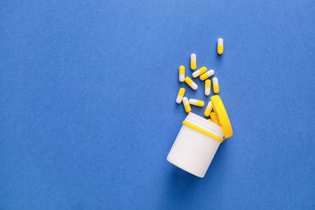 Bottle with capsules on blue background