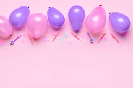 Balloons, candles and confetti on color background