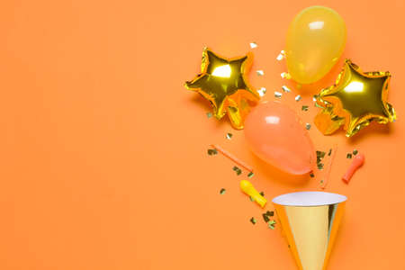 Party hat, balloons, candles and confetti on color backgroundの写真素材