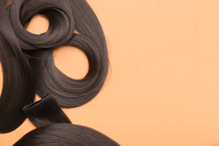 Strands of brown hair on color backgroundの写真素材