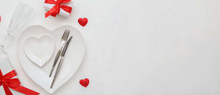 Stylish table setting and gifts for Valentine's Day on white background with space for textの写真素材