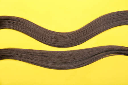 Strands of brown hair on color backgroundの写真素材