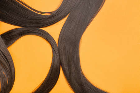 Strands of brown hair on color background, closeupの写真素材