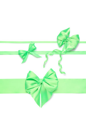 Beautiful green ribbons with bows on white backgroundの写真素材