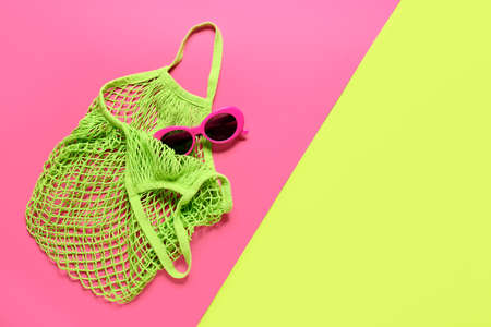Stylish sunglasses and eco bag on color backgroundの写真素材
