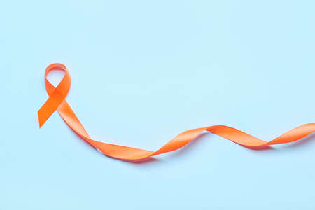 Orange ribbon on color background. Cancer leukemia awareness conceptの写真素材
