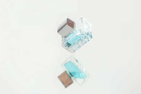 Glass bottle of perfume on mirror