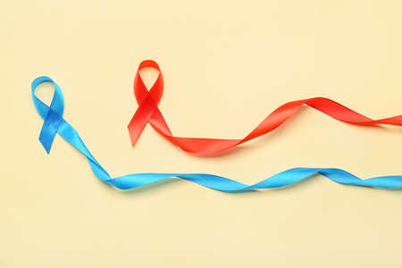 Red and blue ribbons on color background. Cancer aids awareness conceptの写真素材