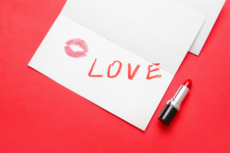 Word LOVE written with lipstick in card on color background, closeupの写真素材
