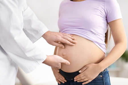 Doctor examining pregnant woman in clinic