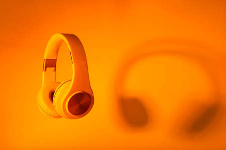 Modern headphones on color backgroundの写真素材
