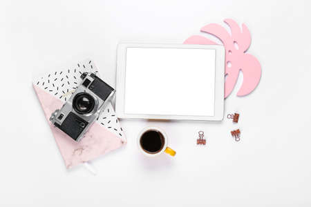 Composition with cup of coffee, tablet computer, photo camera and notebook on white backgroundの写真素材